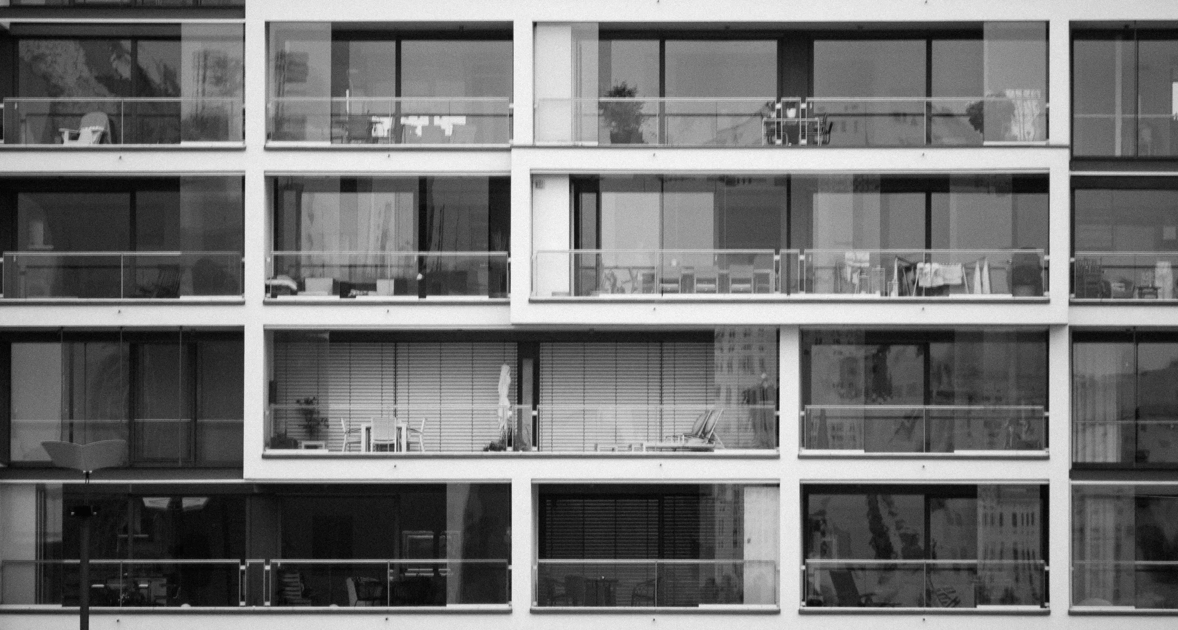 High-rise apartment balconies with various items, black and white photograph.