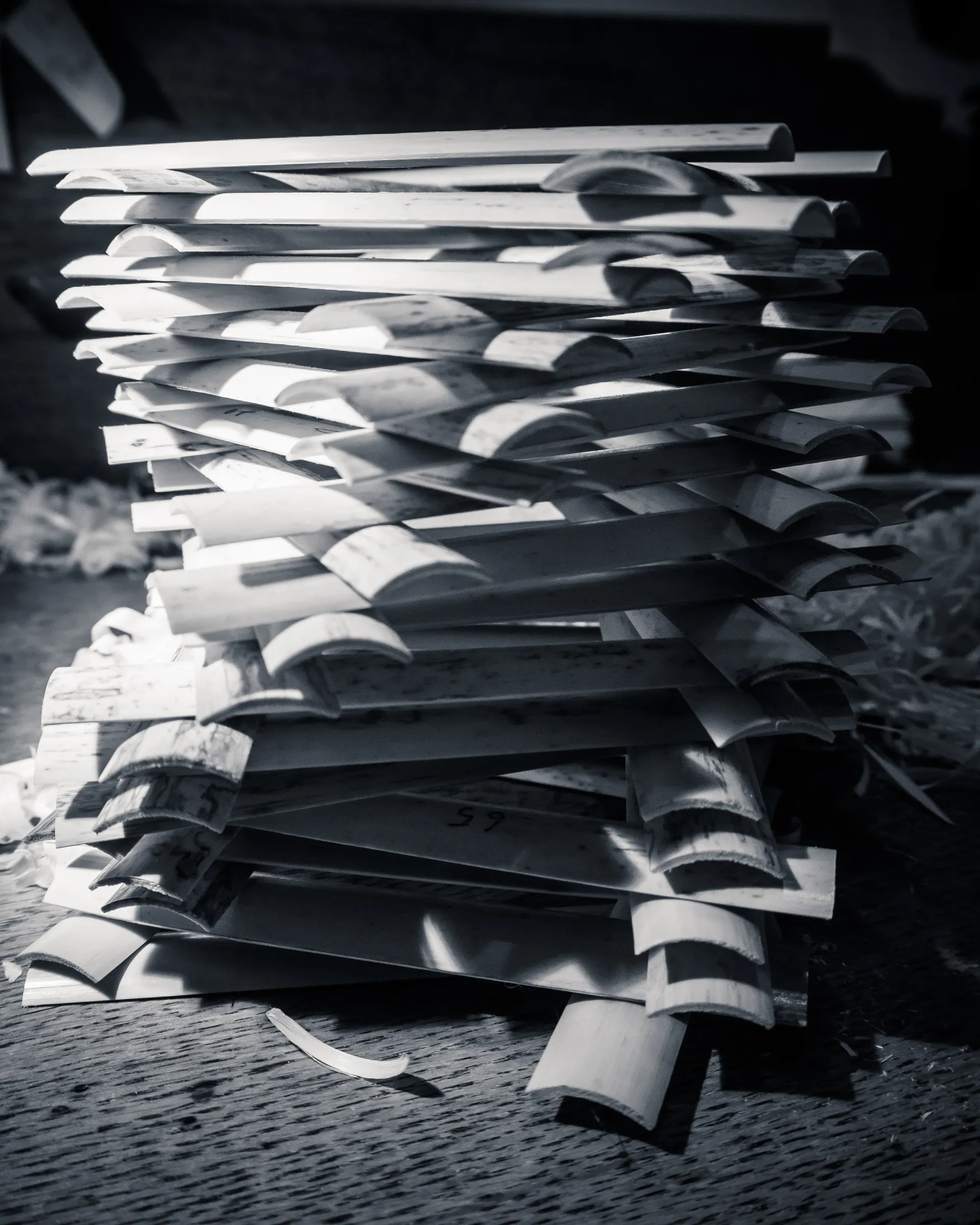 Stacked, open books with visible pages, creating a wave-like pattern. Black and white photograph.
