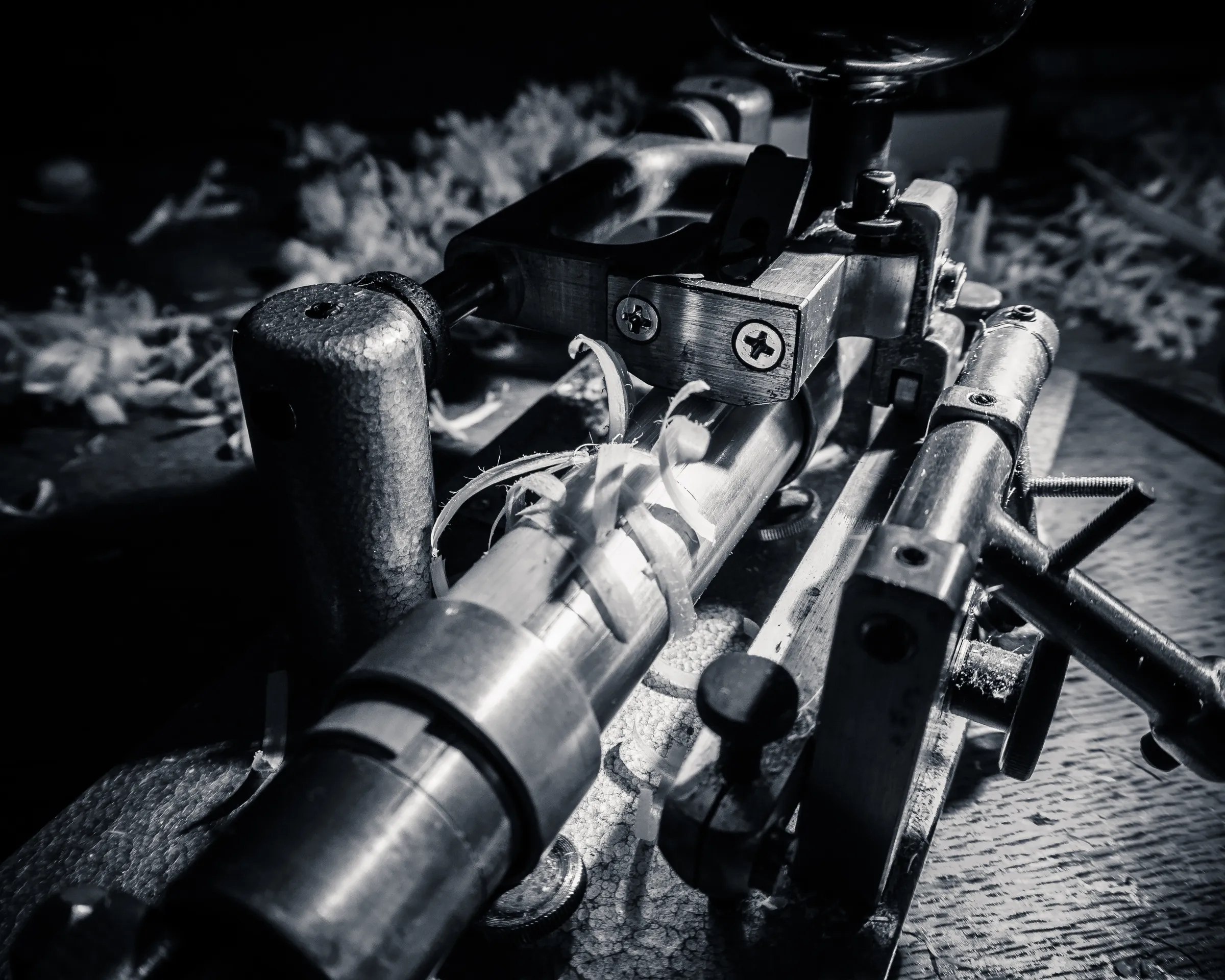 Close-up of an old rifle with a scope, showing detailed parts and worn wooden stock.