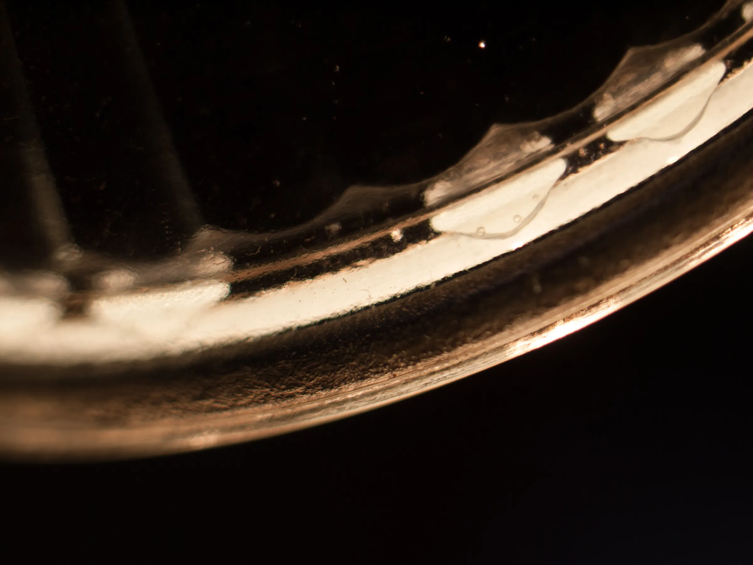 Close-up of a broken eggshell on a dark background, showcasing its delicate, translucent texture and subtle reflections.