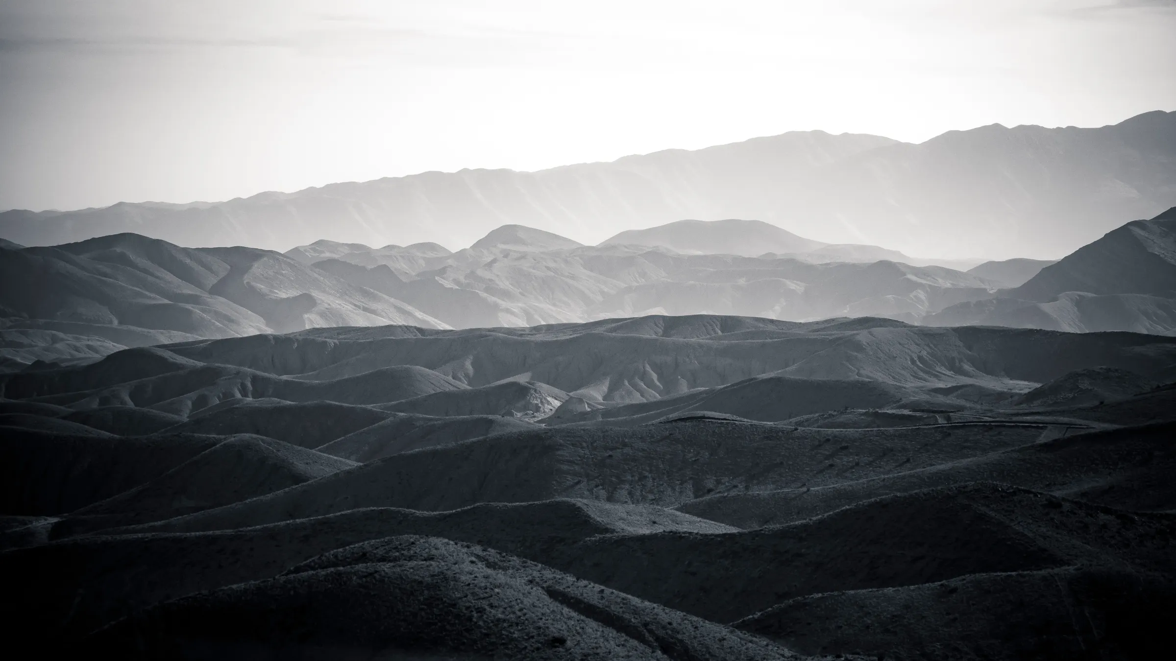 Rugged, undulating desert mountains at dusk.