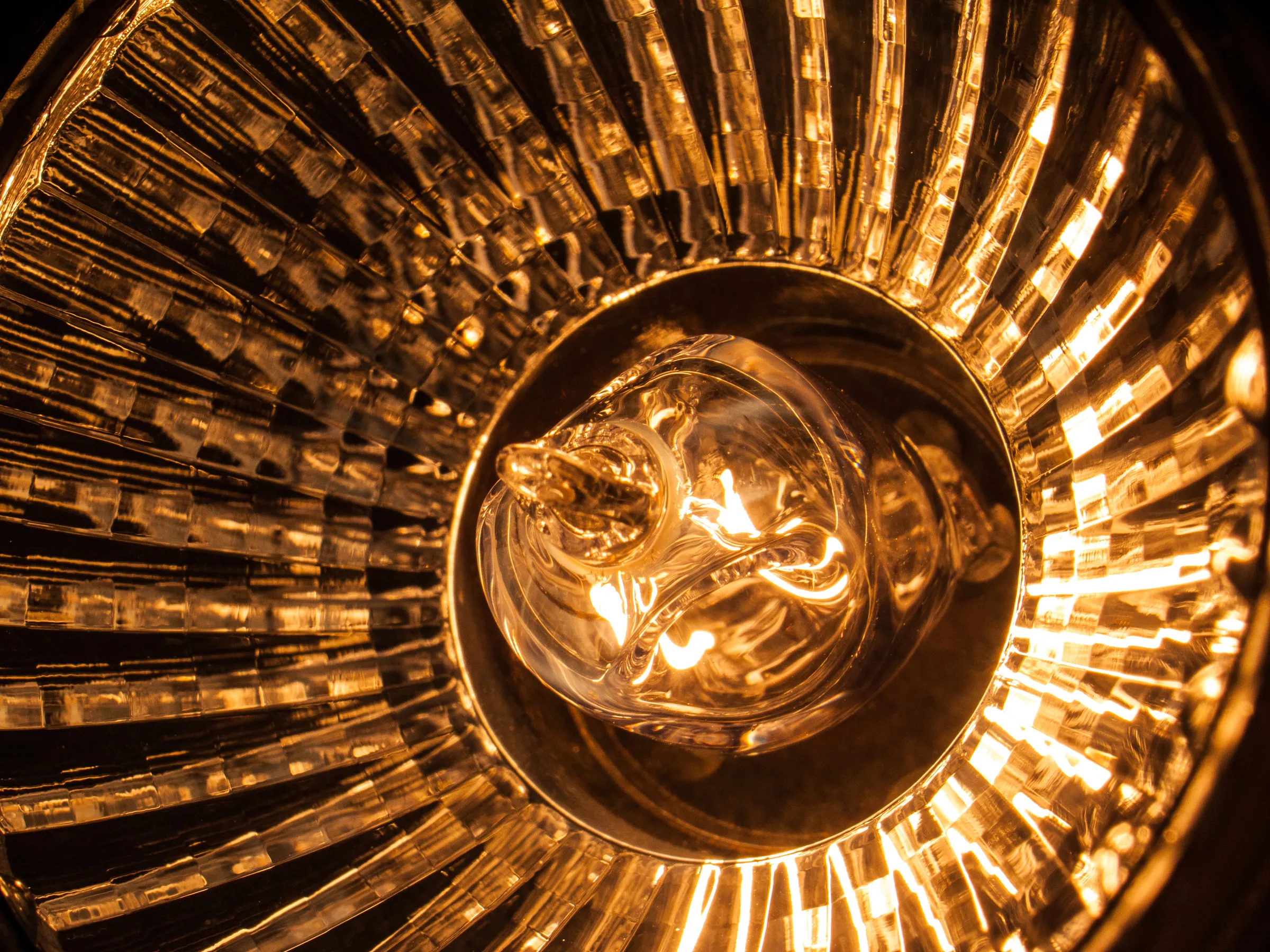 A central light source surrounded by radiating lines, creating a starburst effect, with warm golden tones.