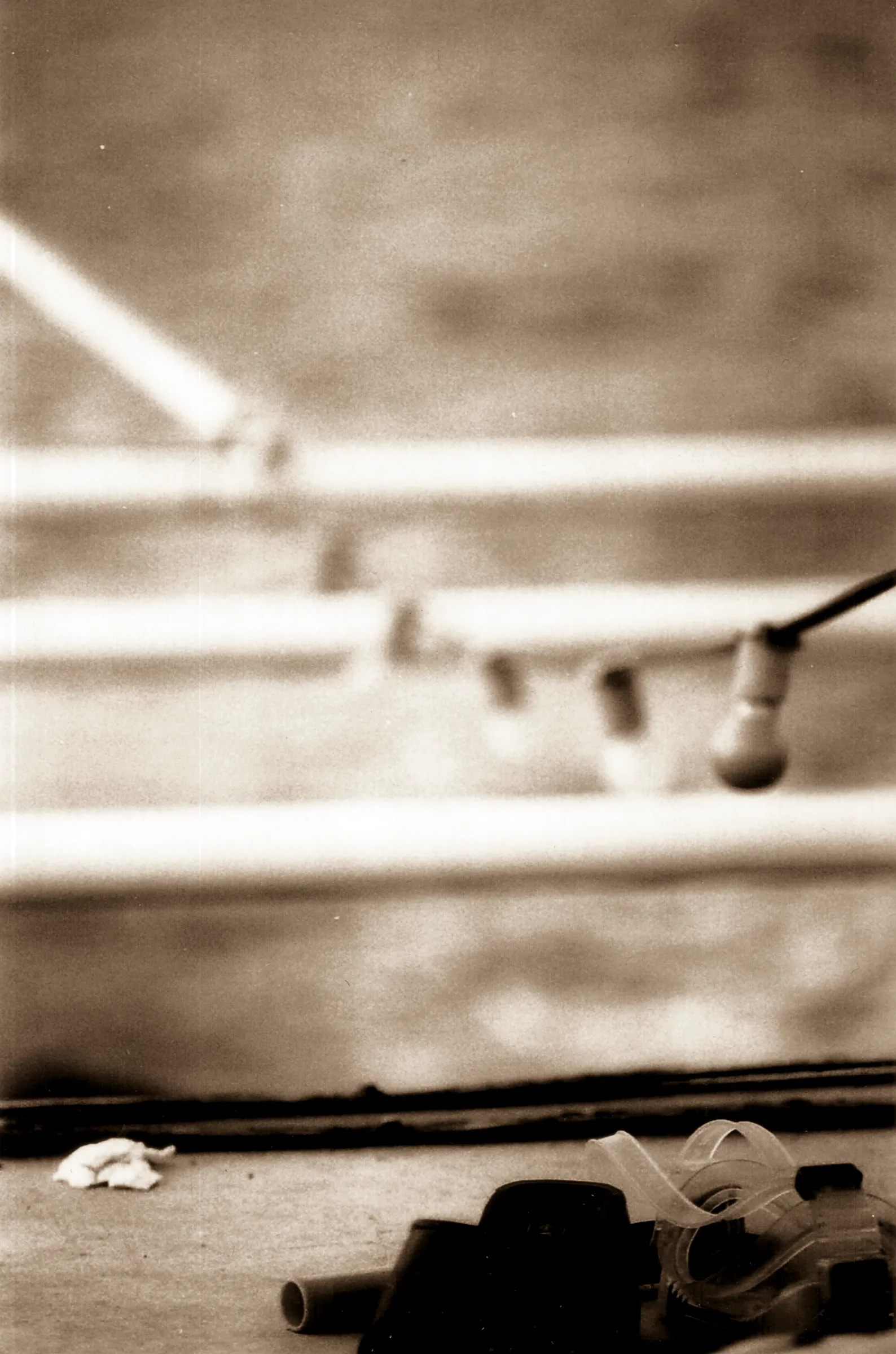 Stairs with a handrail, blurred background, scattered debris on the steps including bottles and paper.
