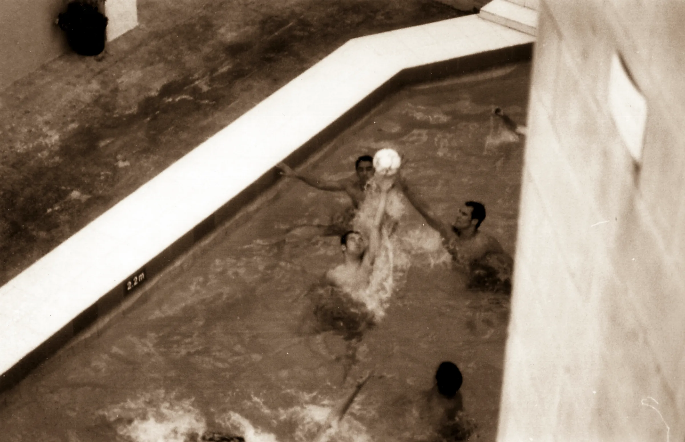 People playing in a shallow pool with water splashing around them