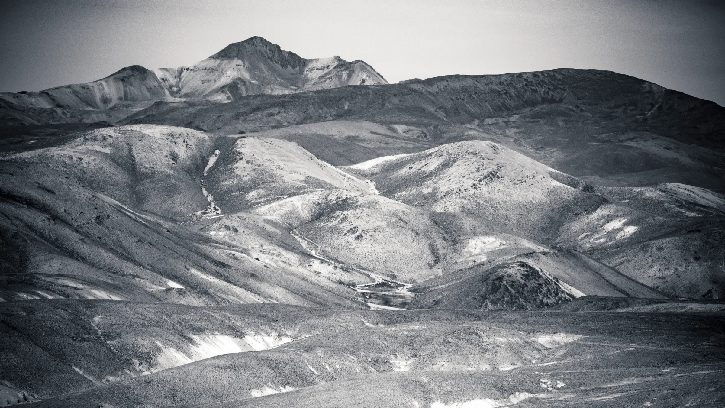 Rugged mountains with rolling hills and valleys, captured in black and white.