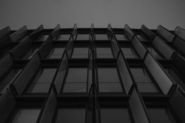 A modern building facade with geometric glass windows in black and white.
