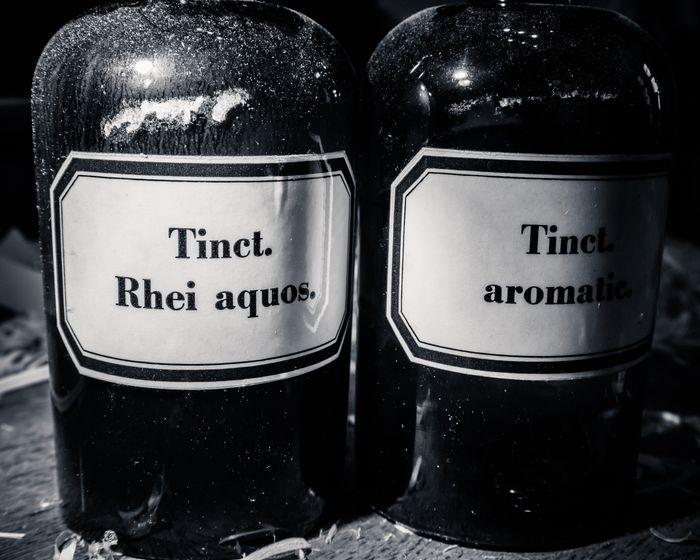 Two black bottles with white labels reading 
