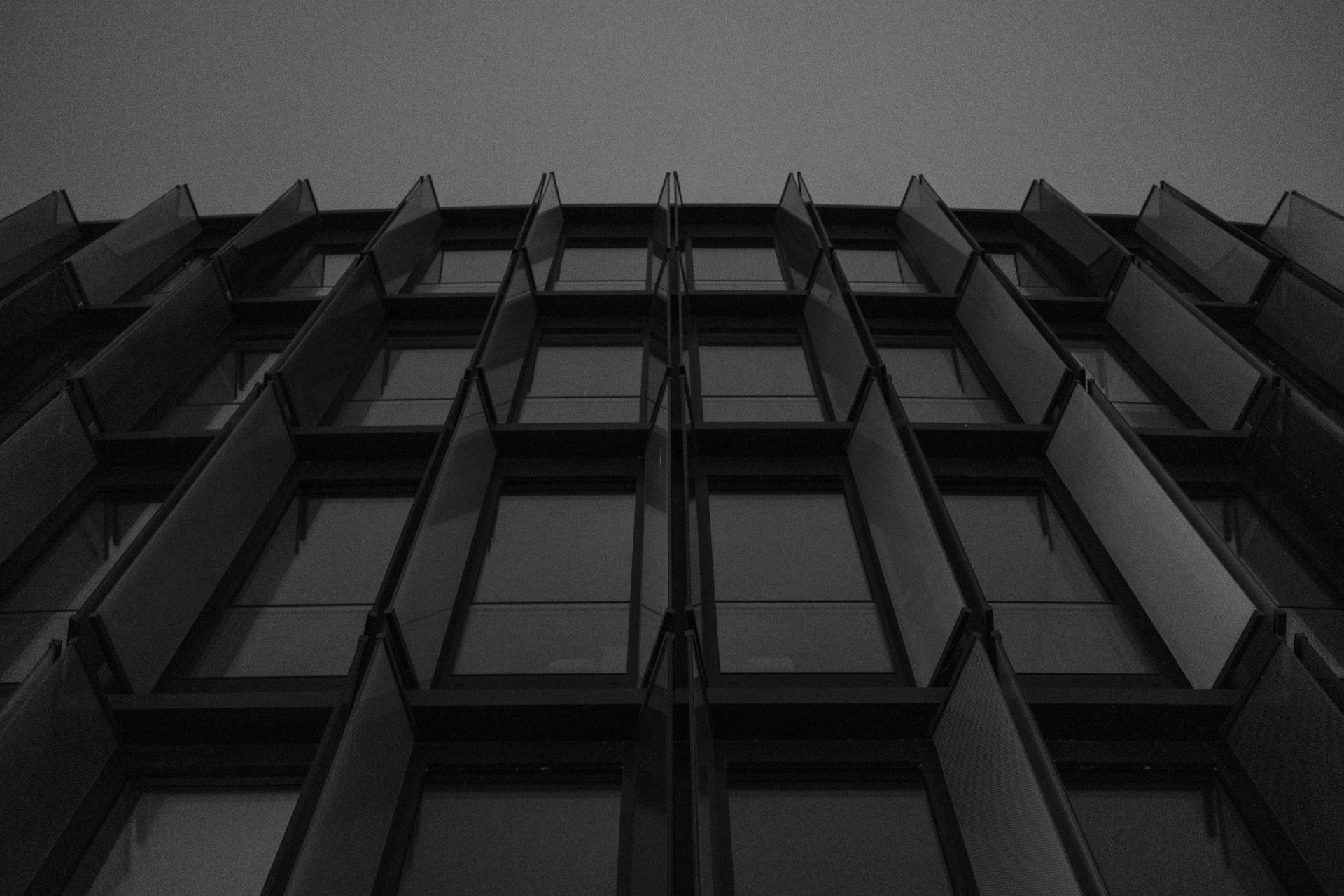 A modern building facade with geometric glass windows in black and white.