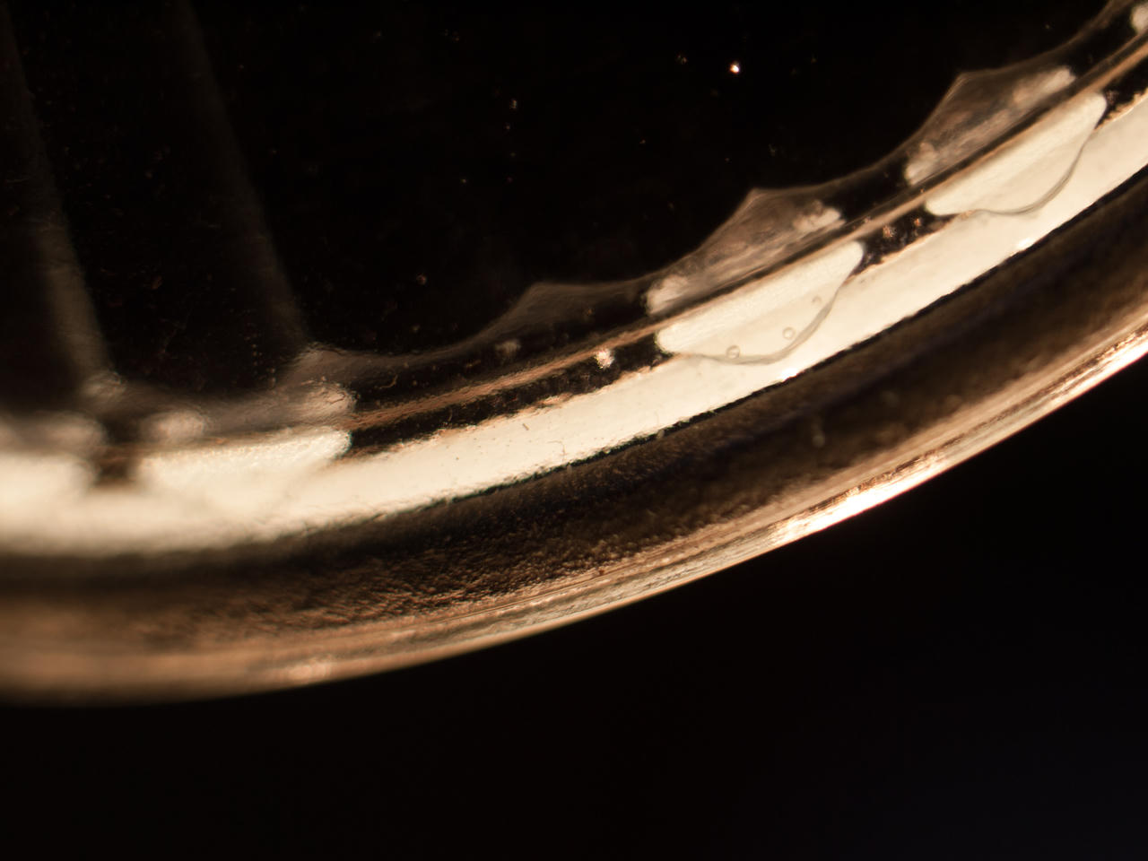 Close-up of a broken eggshell on a dark background, showcasing its delicate, translucent texture and subtle reflections.