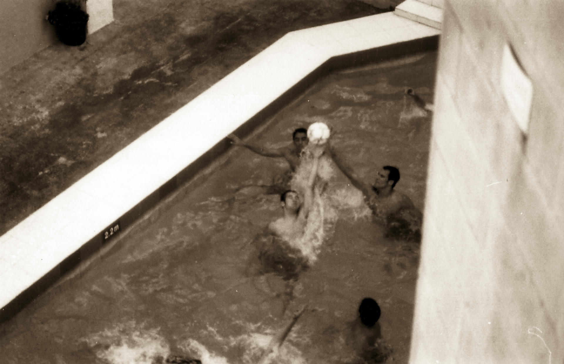 People playing in a shallow pool with water splashing around them