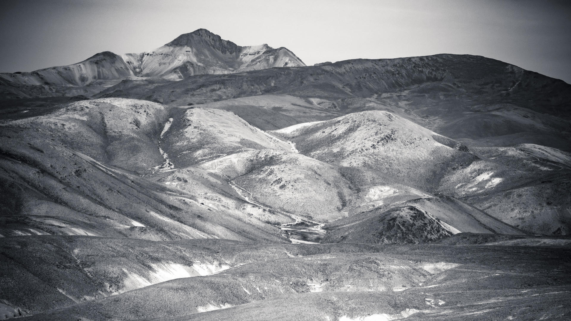 Rugged mountains with rolling hills and valleys, captured in black and white.