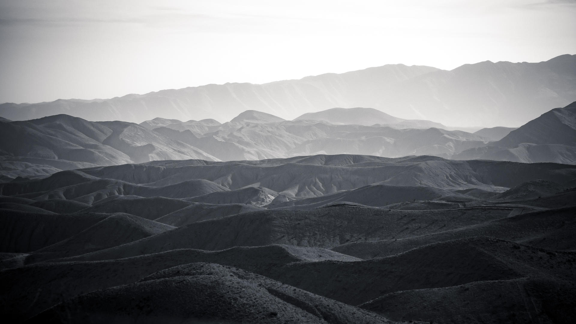 Rugged, undulating desert mountains at dusk.